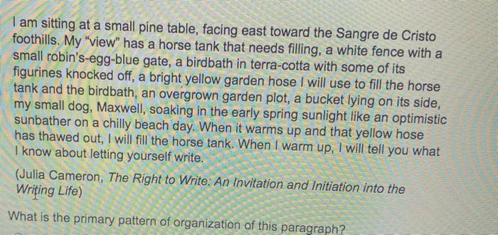 I am sitting at a small pine table, facing east