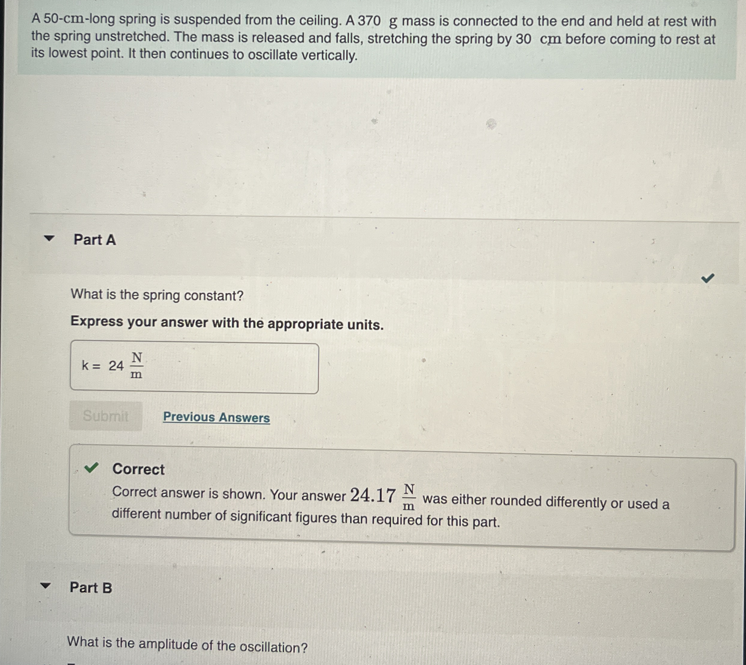 A 5 0 - c m - long spring is suspended from the