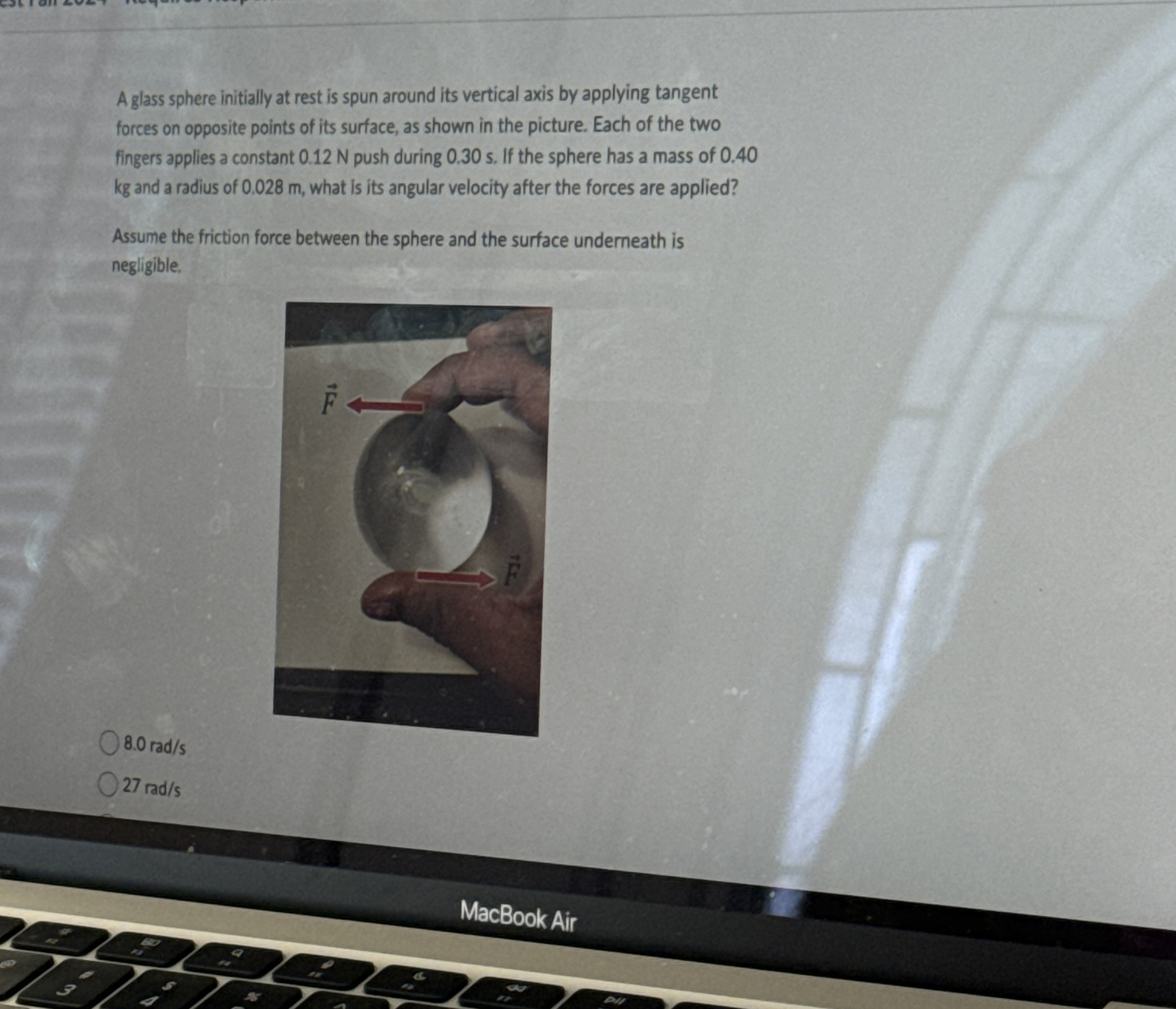 A glass sphere initially at rest is spun around