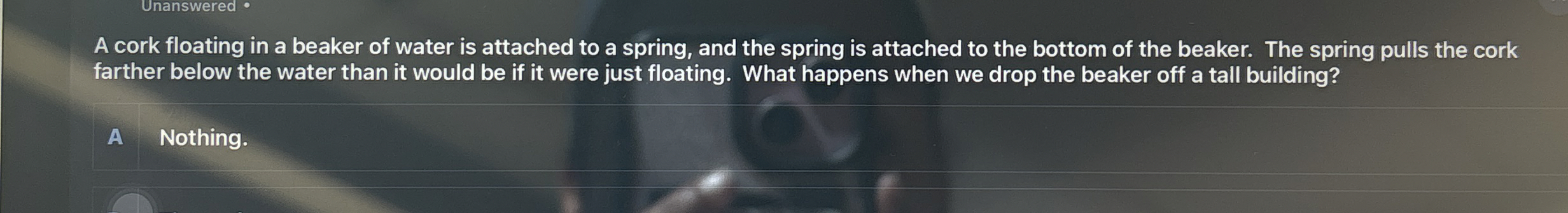 A cork floating in a beaker of water is attached