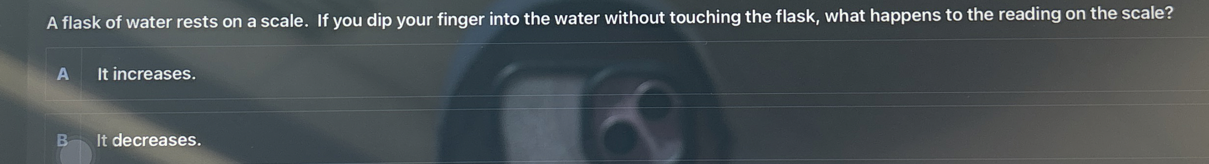 A flask of water rests on a scale. If you dip