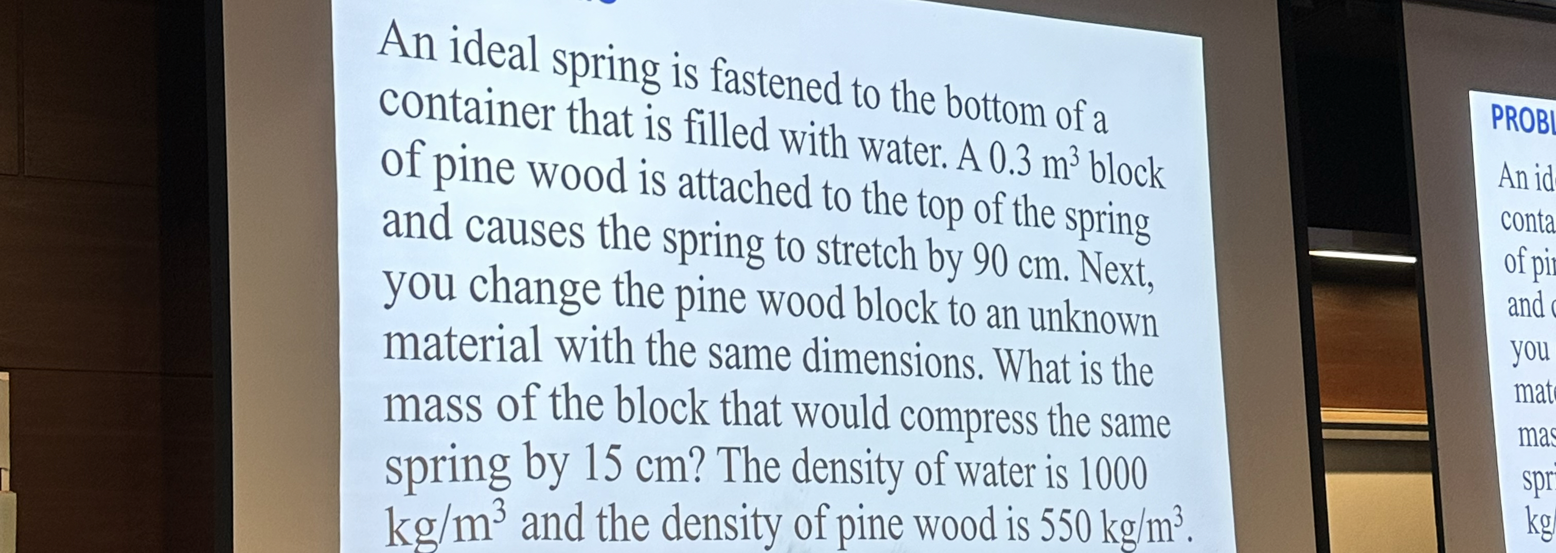 An ideal spring is fastened to the bottom of a