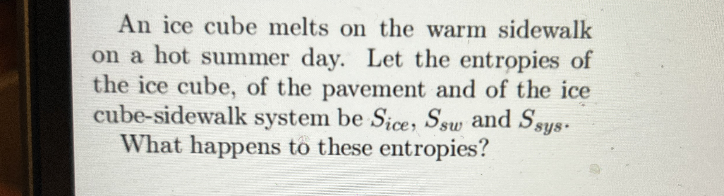 An ice cube melts on the warm sidewalk on a hot