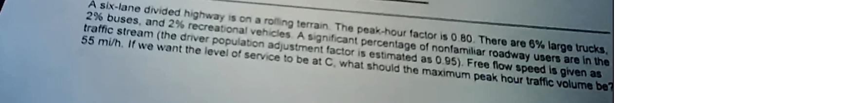 A six - lane divided highway is on a rolling