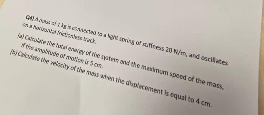 Q 4 ) A mass of 1 k g is connected to a light