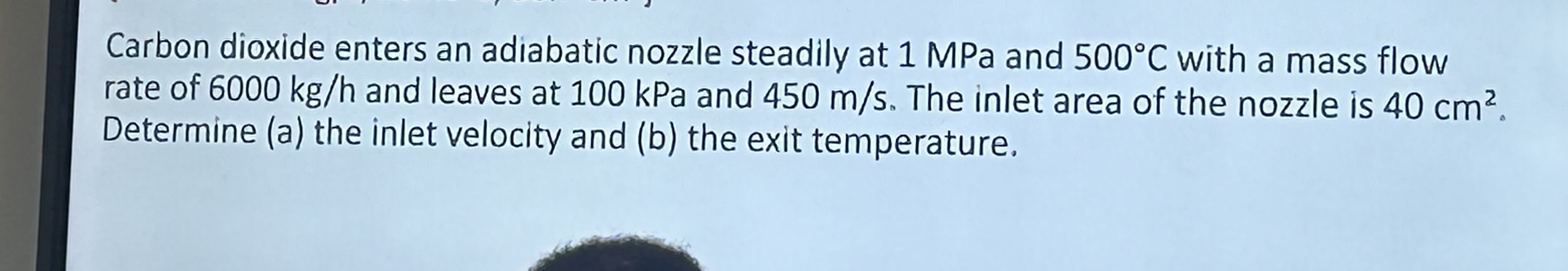 Carbon dioxide enters an adiabatic nozzle