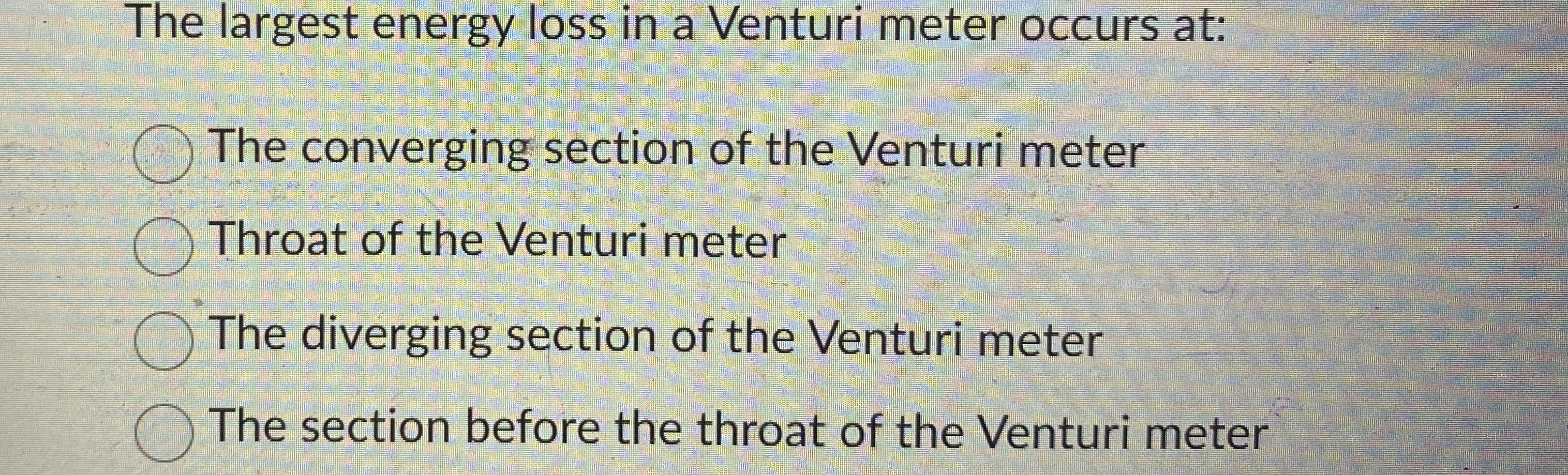 The largest energy loss in a Venturi meter occurs