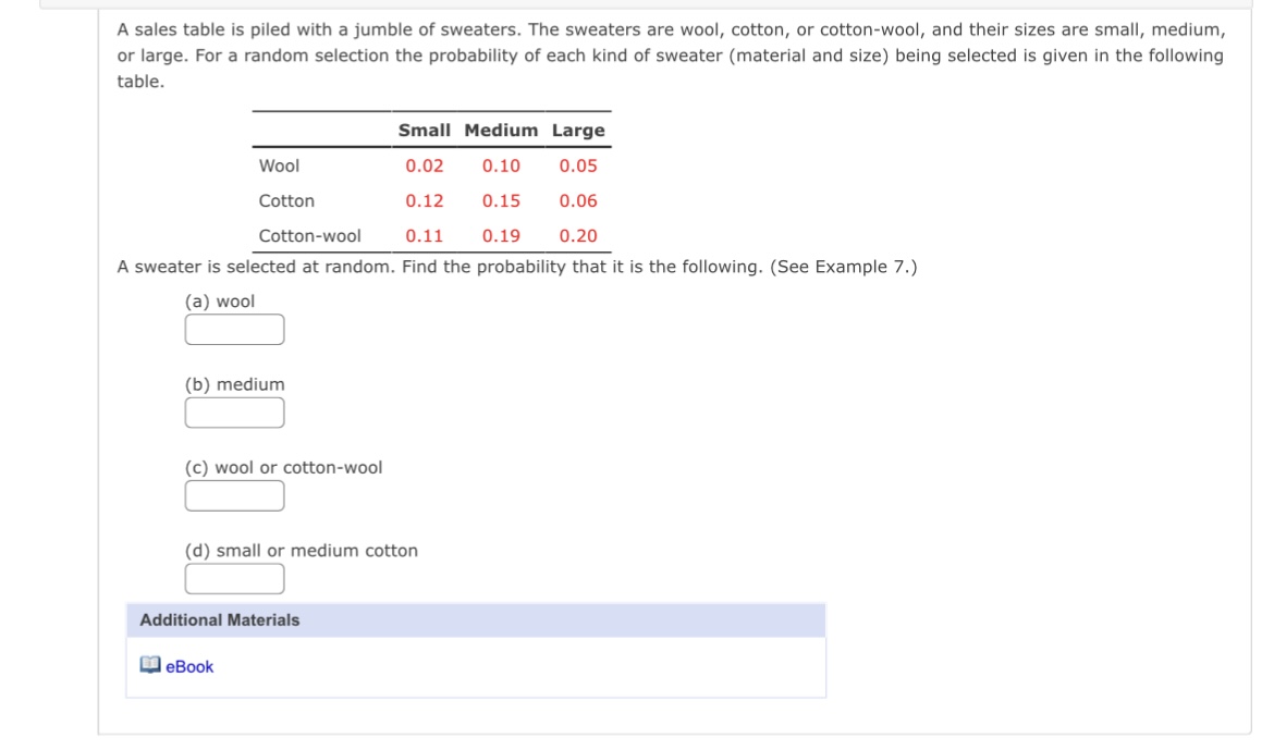 A sales table is piled with a jumble of sweaters.