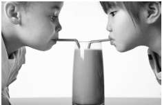 A. Two girls are sharing a cold chocolate milk, as