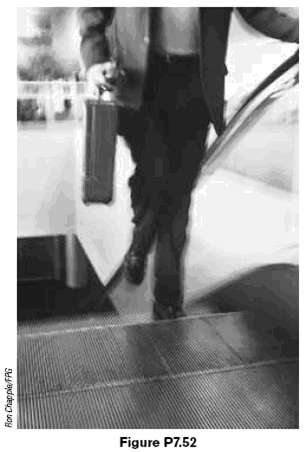 A traveler at an airport takes an escalator
