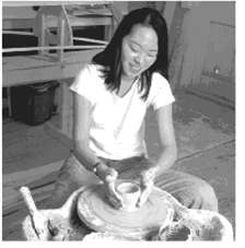 A potter is shaping a bowl on a potter’s wheel